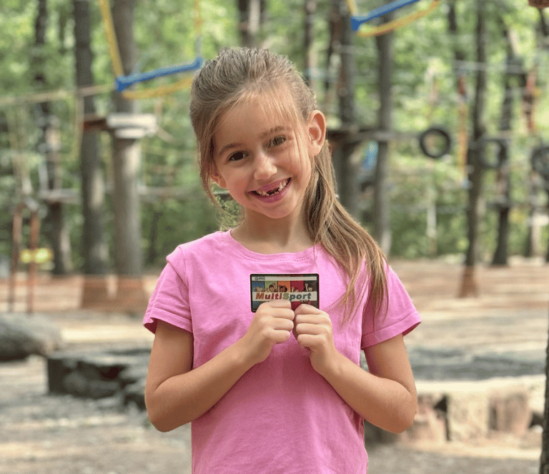 усмихнато момиче държи детска карта MultiSport KIDs